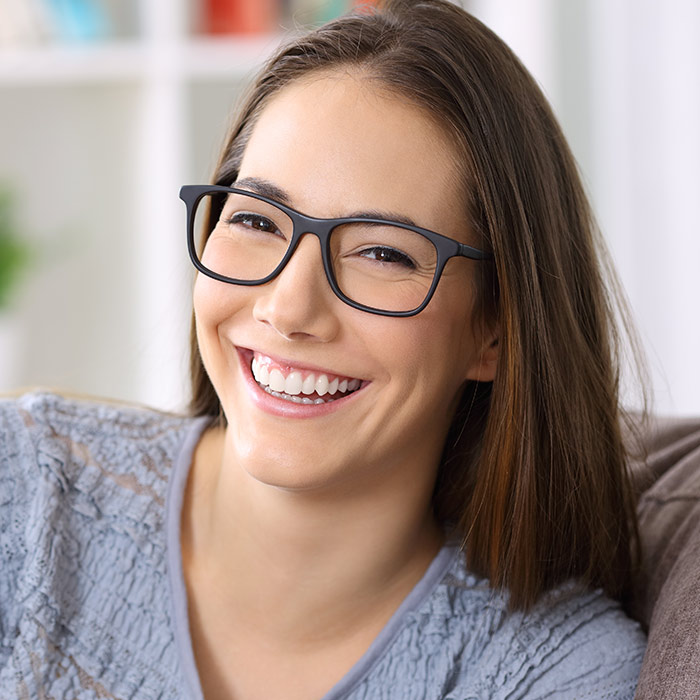 Person smiling with glasses for About Dental & Vision
